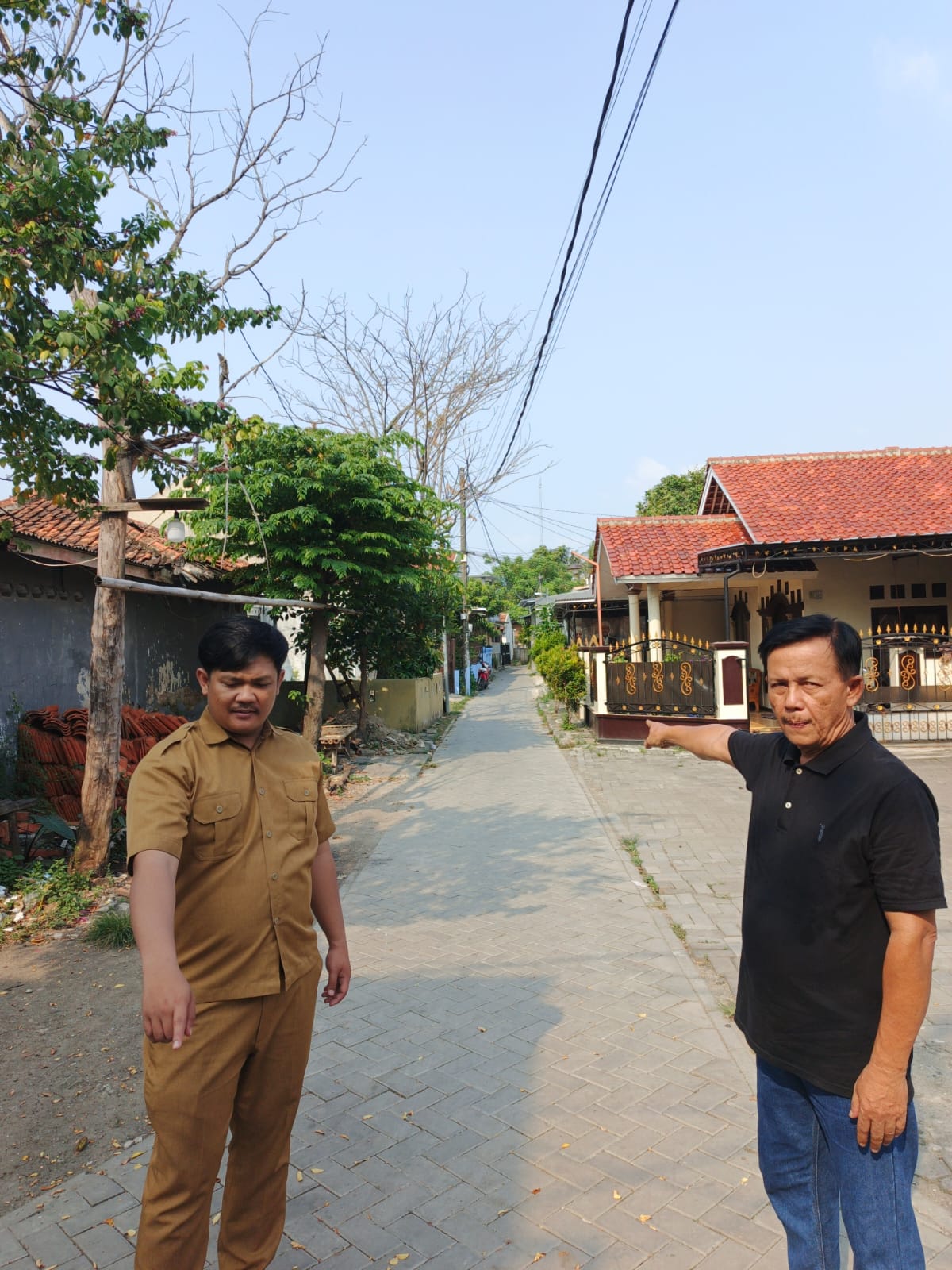 Petugas Dinas PUPR Kota Tangerang bersama ketua RW setempat mengecek jalan lingkungan di RW 09 Belendung yang sudah dipavingblock.